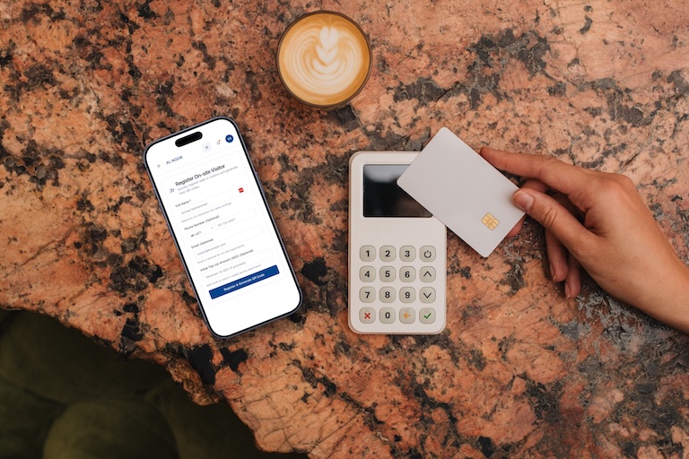 On-site visitor registration desk with staff issuing QR code stickers